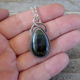 Blue tiger eye and sterling silver pendant on hand