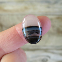 Oval Montana agate cabochon on finger