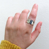Wide band mountain ring on hand